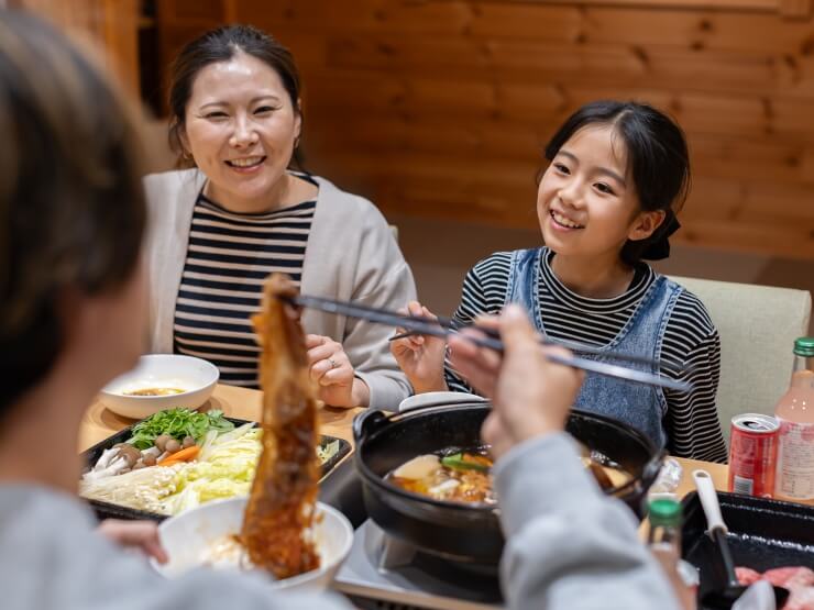 すき焼きを家族で囲んで楽しく過ごしている様子