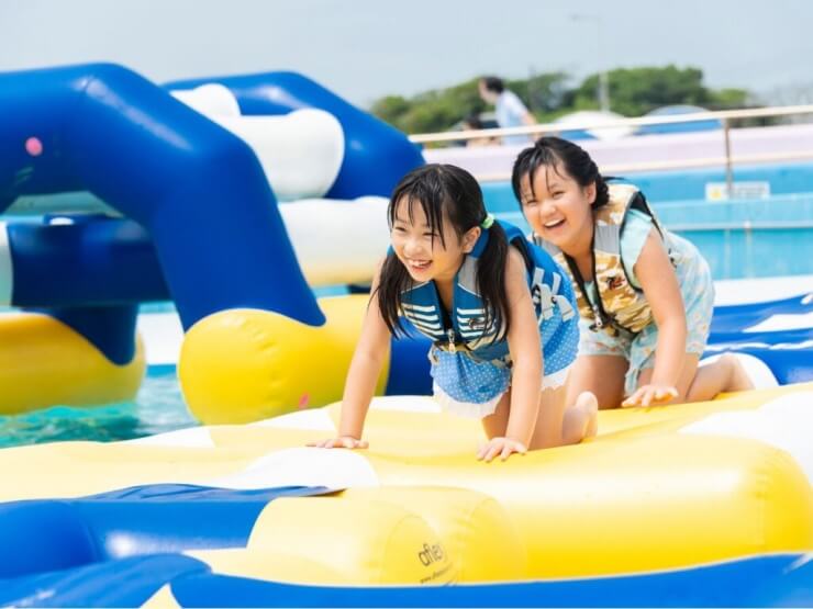 水上アスレチックで遊ぶ子どもたち
