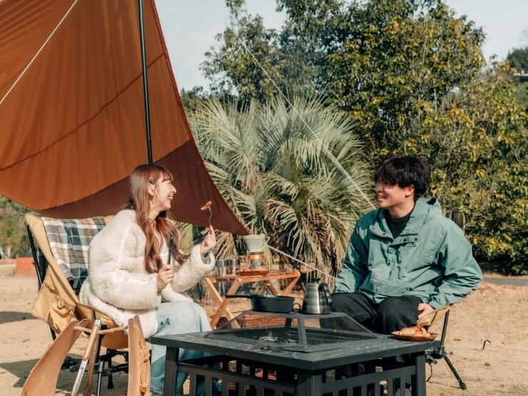 焚き火カフェではしゃぐカップル