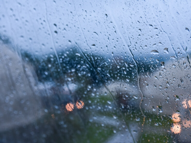 雨のしずくが流れ落ちるドームテントの窓